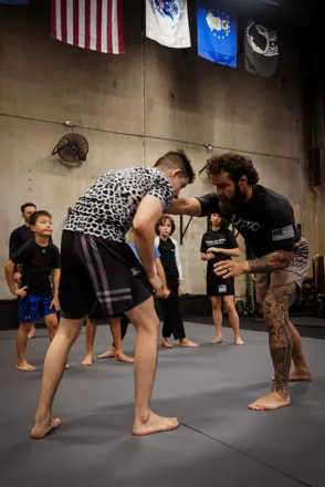 Coach Cam Hurd and Coach Lyndon Yates teaching kids at HYR Grappling